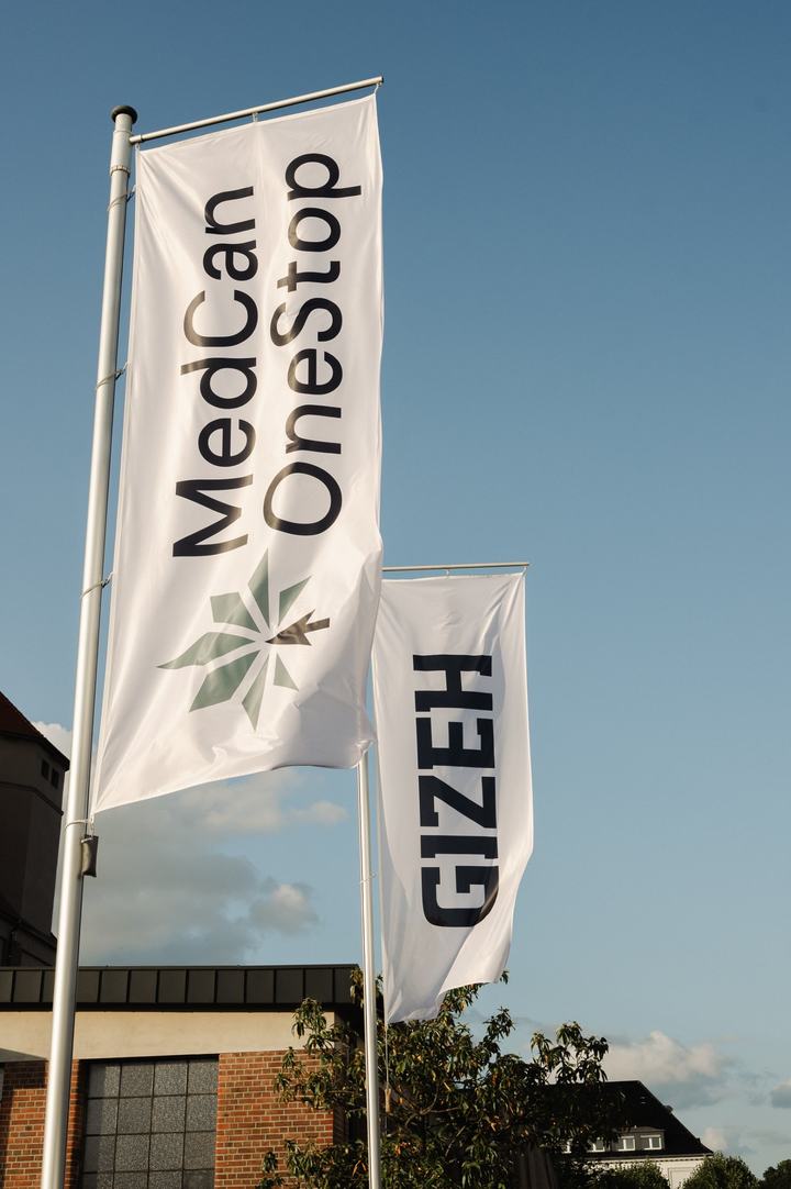 Fahnen von MedCan OneStop und Gizeh vor blauem Himmel